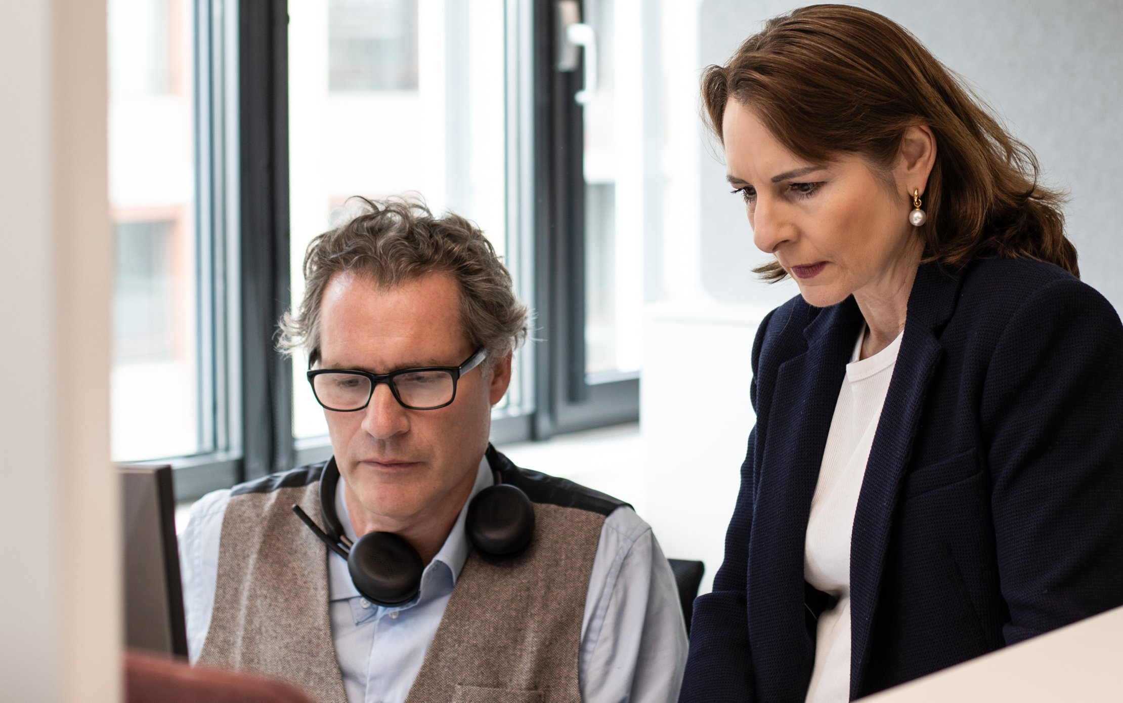 Liliane im Gespräch mit einem Kollegen am Arbeitsplatz bei Profond