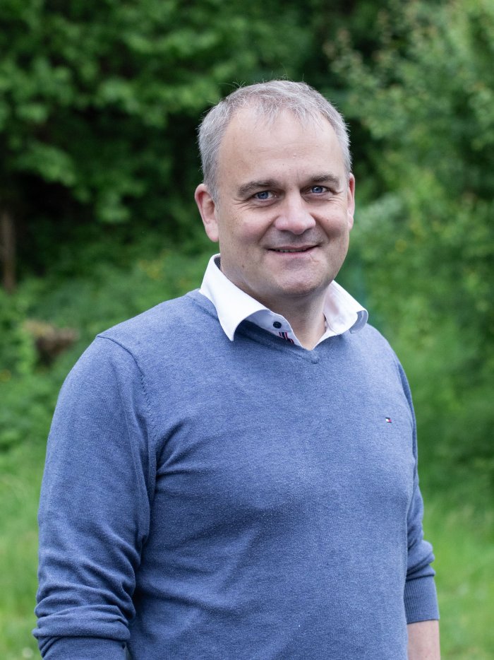 Portrait von Christian Fanger, Co-Geschäftsführer des Profond Kunden Kernser Edelpilze vor grünem Hintergrund